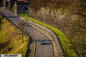 Toyota GT86 Namur – front three-quarter, dark grey on a winding stone road
