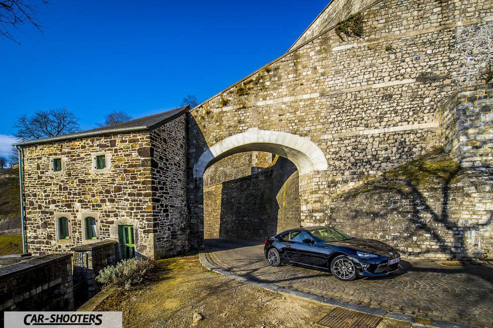 Toyota GT86 Namur – front three-quarter, black parked near an old stone archway