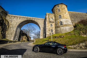 Toyota GT86 Namur – side profile, black on a cobblestone street in front of a stone fortress
