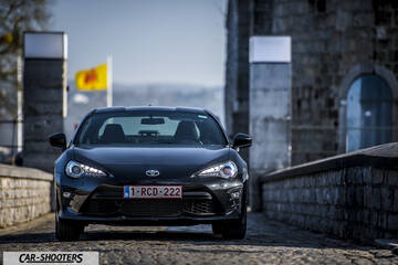 Toyota GT86 Namur – front three-quarter, dark grey metallic on a stone bridge