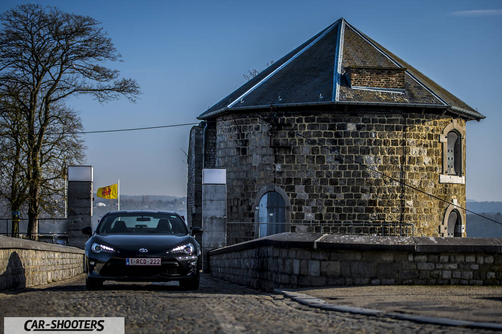 Toyota GT86 Namur – front three-quarter, black against a stone building