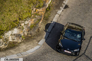 Toyota GT86 Namur – front three-quarter, black on a winding road next to a rock face