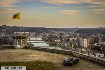 Toyota GT86 Namur – rear three-quarter, black against a city overview backdrop