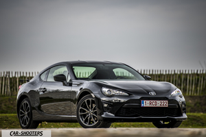 Toyota GT86 Namur – front three-quarter, black against a rural fence backdrop