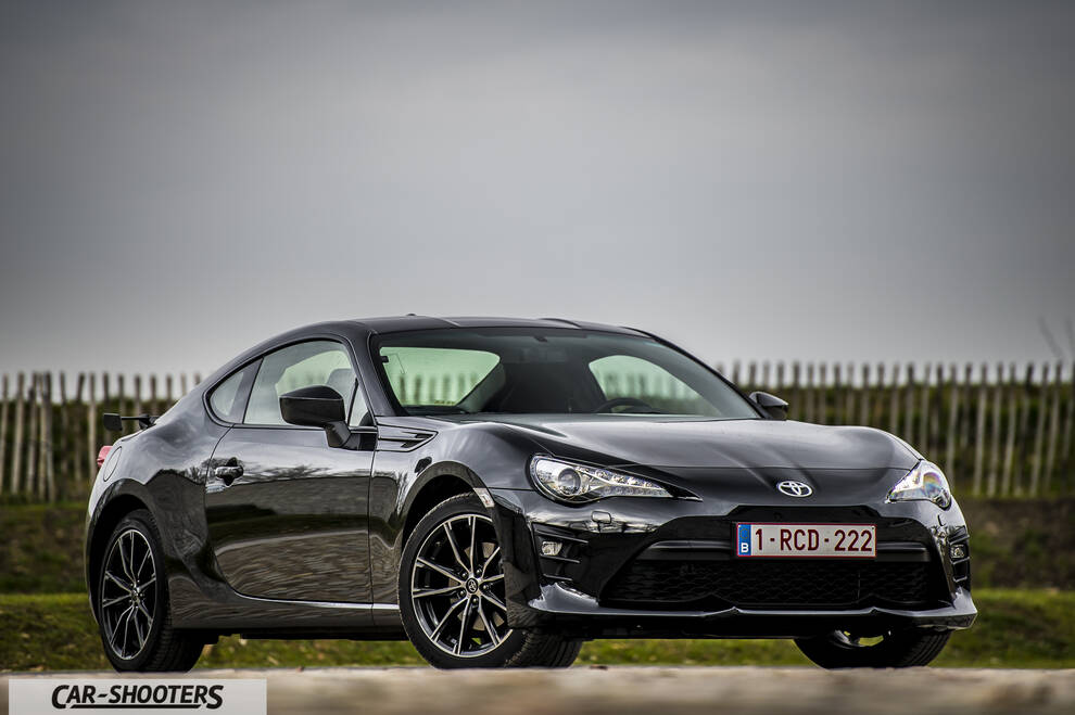 Toyota GT86 Namur – front three-quarter, black against a rural fence backdrop