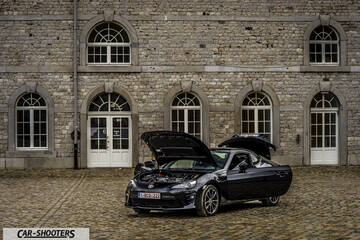 Toyota GT86 Namur – front three-quarter, black against a stone building