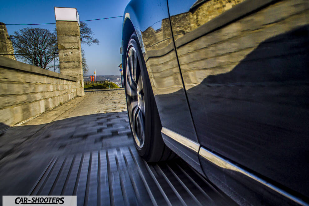 Toyota GT86 Namur – side profile, dark blue driving on a stone street