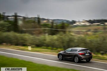 Infiniti Q30 – rear three-quarter, bronze metallic on a country road