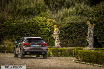 Infiniti Q30 – rear three-quarter, brown metallic in a formal garden