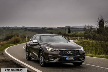 Infiniti Q30 – front three-quarter, brown metallic on a country road
