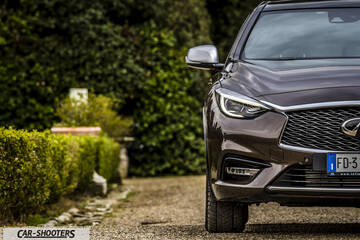 Infiniti Q30 – front three-quarter, brown metallic on a gravel driveway
