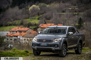 Fiat Professional Fullback – front three-quarter, grey metallic against a mountain village backdrop