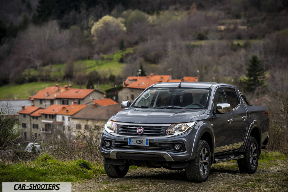 Fiat Professional Fullback – front three-quarter, grey metallic against a mountain village backdrop