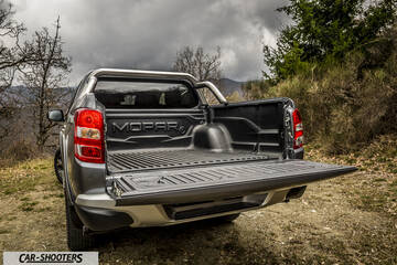 Fiat Professional Fullback – rear view, grey metallic on a dirt road with trees
