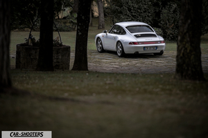 Porsche 993 Carrera 4 – rear three-quarter, white parked on stone ground among trees