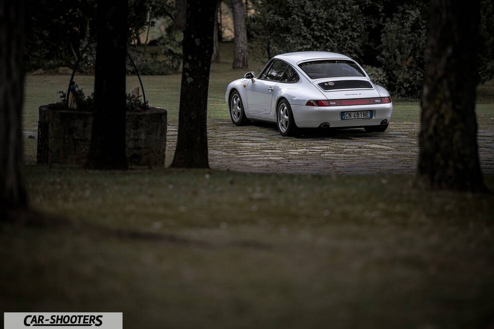 Porsche 993 Carrera 4 – rear three-quarter, white parked on stone ground among trees