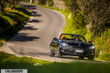 Fiat 124 Spider – front three-quarter, black on a winding country road