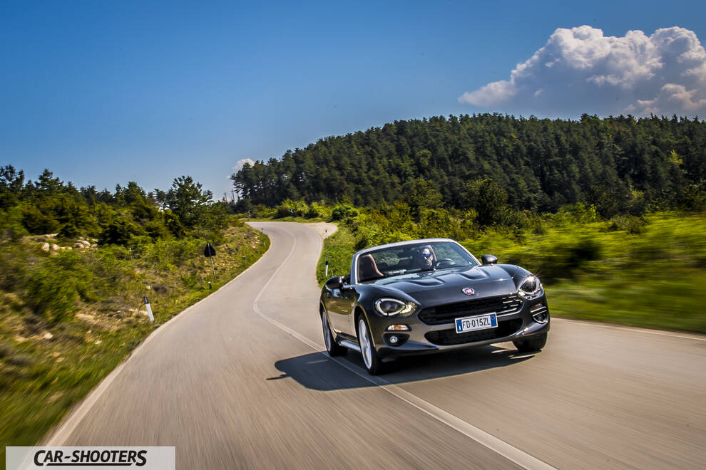 Fiat 124 Spider – front three-quarter, grey metallic on a winding country road