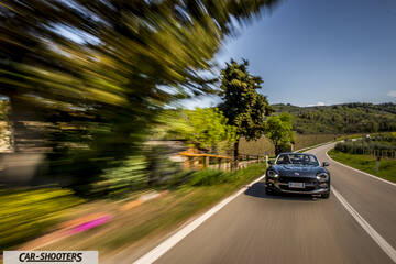 Fiat 124 Spider – front three-quarter, dark grey on a winding country road