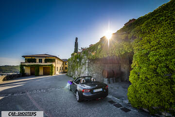 Fiat 124 Spider – rear three-quarter, grey metallic on a paved courtyard