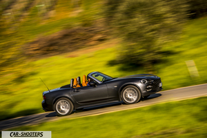 Fiat 124 Spider – side profile, dark grey metallic on a country road