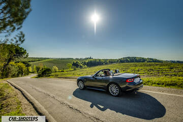 Fiat 124 Spider – rear three-quarter, dark grey on a country road