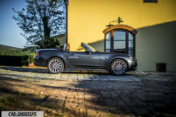 Fiat 124 Spider – side profile, grey metallic against a yellow wall