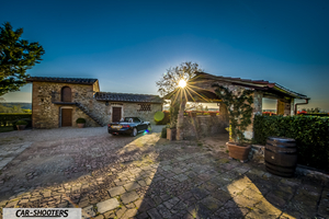 Fiat 124 Spider – rear three-quarter, black parked in a rustic courtyard