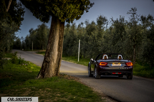 Fiat 124 Spider – rear view, dark grey on a country road