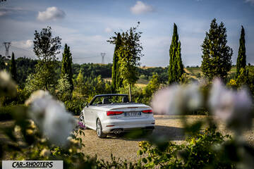 Audi A3 Cabriolet – rear three-quarter, white against a cypress tree backdrop