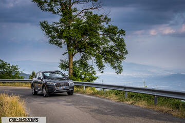 Audi Q5 – front three-quarter, dark grey metallic on a scenic mountain road