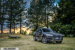 Audi Q5 – front three-quarter, dark grey metallic on a grassy clearing