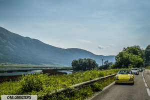Porsche 911 e 912 – front three-quarter, yellow on a scenic mountain road