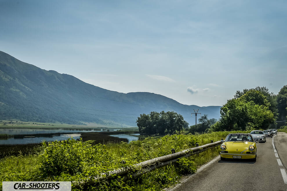 Porsche 911 e 912 – front three-quarter, yellow on a scenic mountain road