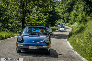 front three-quarter, blue metallic on a country road