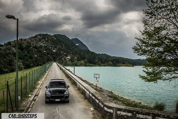 front three-quarter, black on a narrow road by a lake