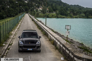 front three-quarter, dark grey on a road beside a lake