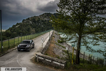 front three-quarter, black on a road near a lake
