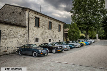 front three-quarter, dark green parked in a row by a stone building