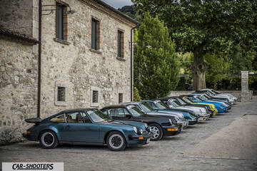 front three-quarter, dark teal parked in front of a stone building