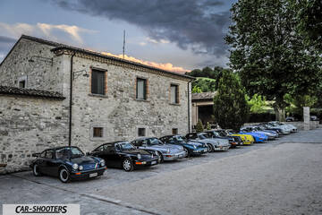front three-quarter, parked in a row outside a stone building