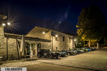 front three-quarter, black parked outside a stone building at night