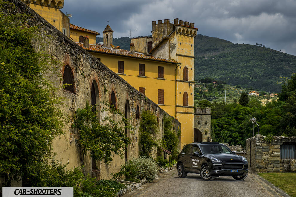 Porsche Cayenne Platinum Edition – front three-quarter, black against a historic building and mountains