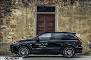 Porsche Cayenne Platinum Edition – side profile, black against an old stone wall