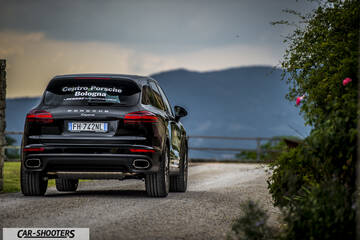 Porsche Cayenne Platinum Edition – rear three-quarter, black on a country road