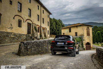 Porsche Cayenne Platinum Edition – rear three-quarter, black on a cobbled street next to old buildings