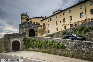 Porsche Cayenne Platinum Edition – side profile, black against an old castle backdrop