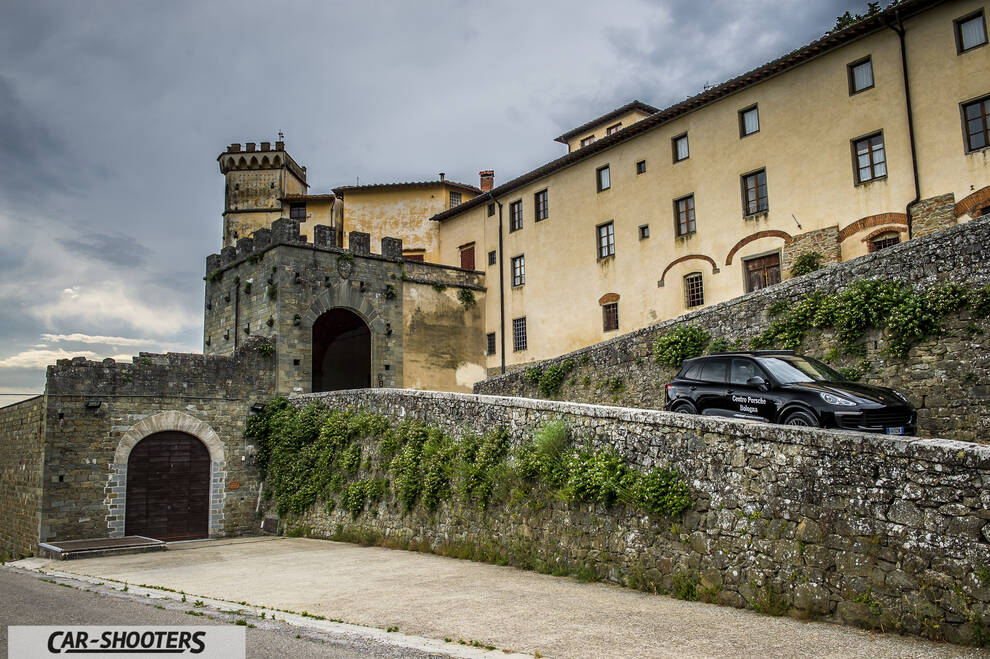 Porsche Cayenne Platinum Edition – side profile, black against an old castle backdrop