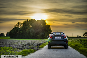 Toyota C HR – rear view, black on a rural road at sunset