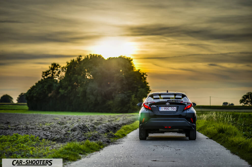 Toyota C HR – rear view, black on a rural road at sunset
